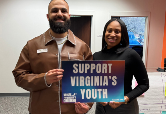 Two members of NextUp staff holding a sign that reads "Support Virginia's Youth"