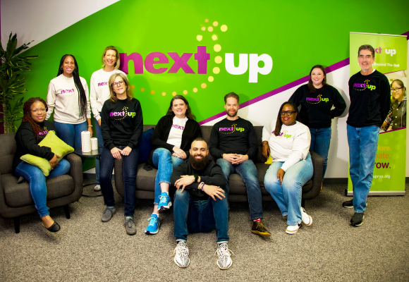 Members of NextUp's staff pose as a team in their office in Richmond, VA