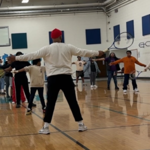 SportsMax instructor leading an extended learning tennis lesson for RPS middle schoolers