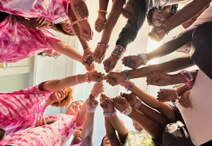 Group of girls in the Greater Richmond Fit4Kids summer programs supported by the City of Richmond's Positive Youth Development funding huddle together smiling and laughing.