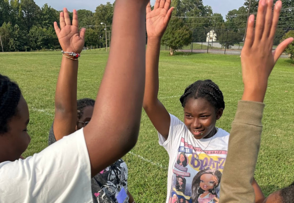 Richmond youth raising their hands in a cheer together in their afterschool programs at Richmond Public Schools
