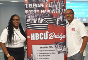 Kristen and Rufus Johnson pose in front of a poster for their HBCU Bridge program in Richmond, VA.
